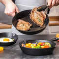 Person cooking steak and vegetables in a black frying pan on a kitchen counter.