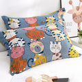  Pair of Cat Party cotton pillowcases in blue with playful cat illustrations, arranged neatly on a white sofa near a giraffe wall art.