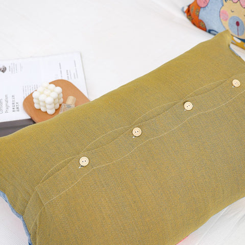 Back view of Cat Party cotton pillowcase in mustard yellow with secure button closure on a white bed, showing textured fabric and neat stitching.