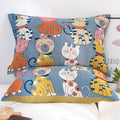 Two colorful Cat Party cotton pillowcases with playful cat illustrations on a blue background, displayed on a white bed.