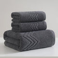 Stack of gray bath towels with textured pattern on a white surface
