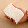 Hand holding natural coconut fiber cleaning sponge