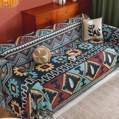 Colorful Aztec blanket used as sofa cover with bold tribal patterns and soft woven fabric.