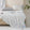 Soft, breathable gray bed blanket draped over beige bed with matching pillows and a light, airy setting