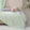 Soft, breathable mint green bed blanket draped over beige bed with matching pillows and a light, airy setting