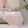 Soft, breathable pink bed blanket draped over beige bed with matching pillows and a light, airy setting