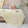 Soft, breathable yellow bed blanket draped over beige bed with matching pillows and a light, airy setting
