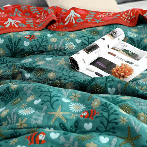 Close-up of Coral Reef Boho Cotton Throw Blanket showing detailed sea life and floral patterns in coral and teal colors