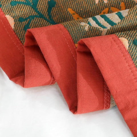 Close-up of Coral Reef Boho Cotton Throw Blanket red-orange edges stitching showing quality craftsmanship.