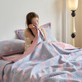 Woman hugging soft quilt with pink and blue reversible pattern