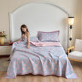 Girl smiling on pastel pink and blue cotton gauze quilt with polka dot design