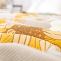 Close-up of breathable gauze cotton texture with yellow and brown floral pattern
