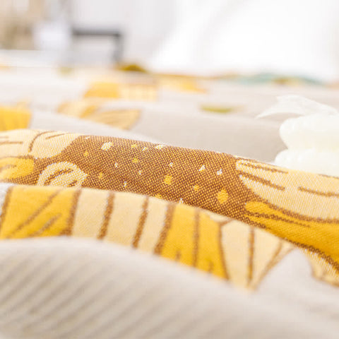 Close-up of breathable gauze cotton texture with yellow and brown floral pattern
