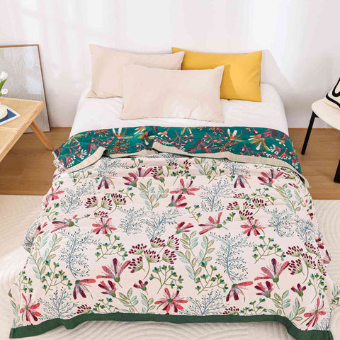 Full view of Alba floral gauze blanket spread on bed with yellow pillows

