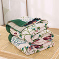 Folded lightweight floral cotton blanket on wooden nightstand

