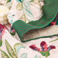 Stitched edge detail of green striped border on summer gauze blanket

