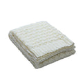 Folded cream blanket with textured pattern on white background