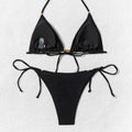 Black triangle bikini set hanging on wooden rack – minimalist display