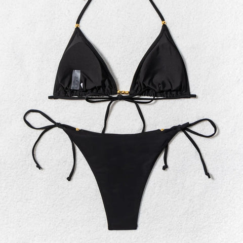 Black triangle bikini set hanging on wooden rack – minimalist display