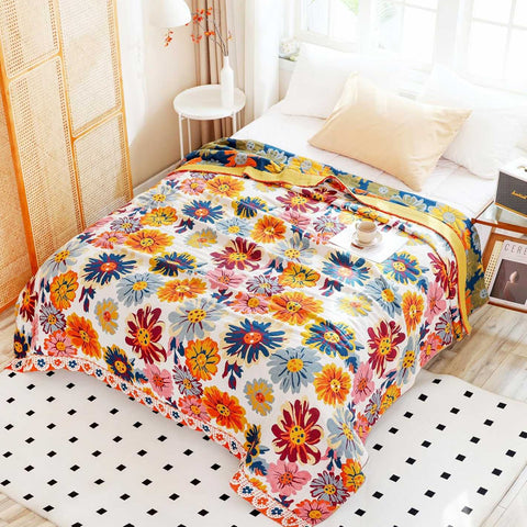 Top view of full spread Daisy Flower Cotton Blanket on a bed with cup of tea and tray, pictures, window, carpet