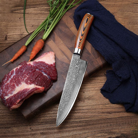 Damascus chef knife on cutting board with raw meat