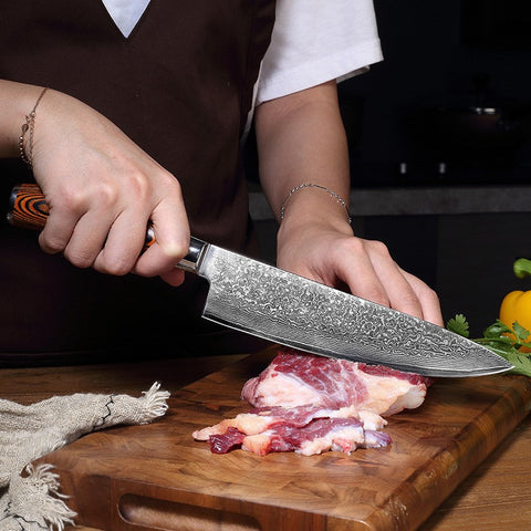 Chef using Damascus knife to slice raw chicken