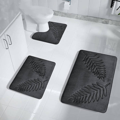 Three-piece dark gray bath mat set for toilet and shower area with embossed fern design