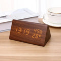 Wooden digital clock displaying time, temperature, and humidity on a wooden surface.