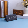 Two digital clocks on a blue surface with books and a vase in the background