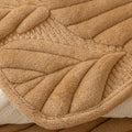 Zoomed-in texture of non-slip camel sofa cover with leaf stitching