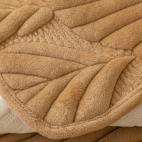 Zoomed-in texture of non-slip camel sofa cover with leaf stitching