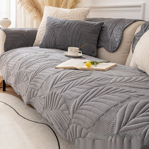 Dark gray plush non-slip sofa cover with pillows on modern couch