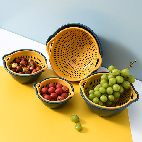 Set of yellow and blue colanders with fruits on a yellow surface