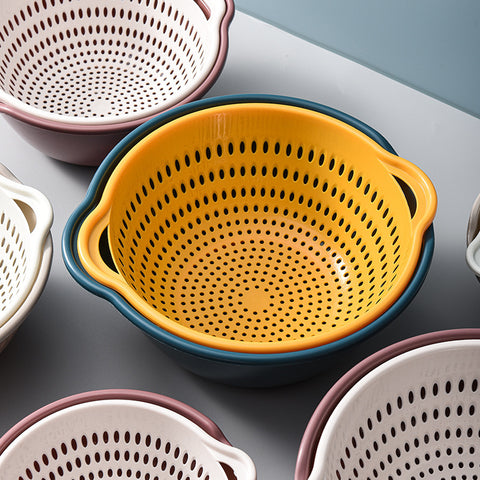 Set of colorful colanders on a gray surface