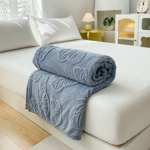 Dusty blue fleece blanket with raised butterfly detail – cozy sofa or bed throw