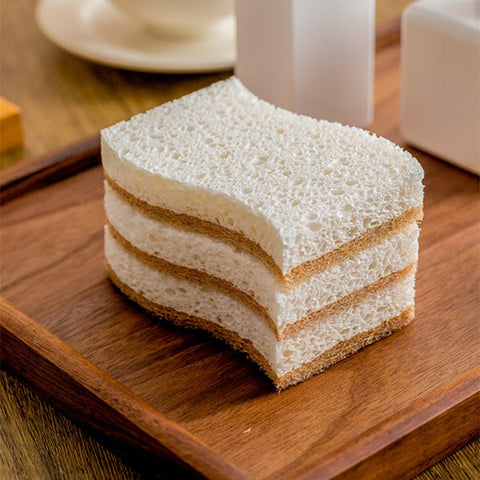 Stack of Kohana coconut fiber sponges on wooden tray