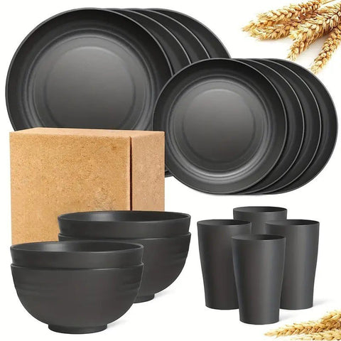 Set of black ceramic plates, bowls, and cups with a cardboard box on a white background.