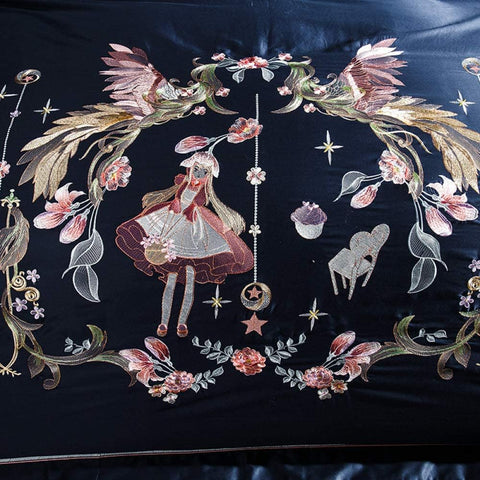 Close-up of girl and floral embroidery on navy satin duvet cover with fairy-tale motif