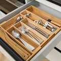 Wooden cutlery organizer with silverware in a kitchen drawer
