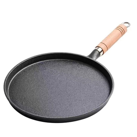 Black frying pan with a wooden handle on a white background