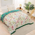 Floral Serenity cotton quilt blanket with reversible design spread on a bed in a bright bedroom with modern decor and natural light.