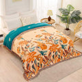Floral patterned blanket on a bed in a bedroom with a plant and side table.