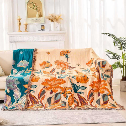 Floral-patterned blanket draped over a couch in a living room setting.