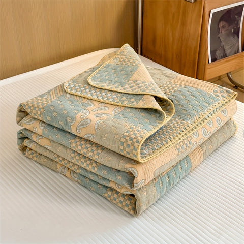 Folded cotton jacquard summer quilt in muted green and beige tones