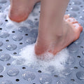 Foot stepping on foamy surface of gray non-slip mat