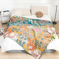 Cozy bedroom with colorful Garden Bloom cotton blanket spread on bed, featuring vibrant floral patterns in breathable cotton fabric.
