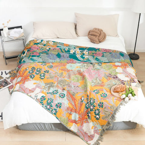 Cozy bedroom with colorful Garden Bloom cotton blanket spread on bed, featuring vibrant floral patterns in breathable cotton fabric.