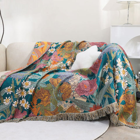 Cozy living room with vibrant Garden Bloom cotton blanket draped over sofa, featuring floral patterns in rich colors