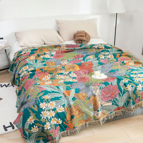 Bright bedroom with floral Garden Flower cotton blanket spread on bed, showcasing colorful flowers and leaves in soft, breathable fabric