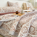Close up detail of geometric leaf pattern on quilt bedding set showing texture and design